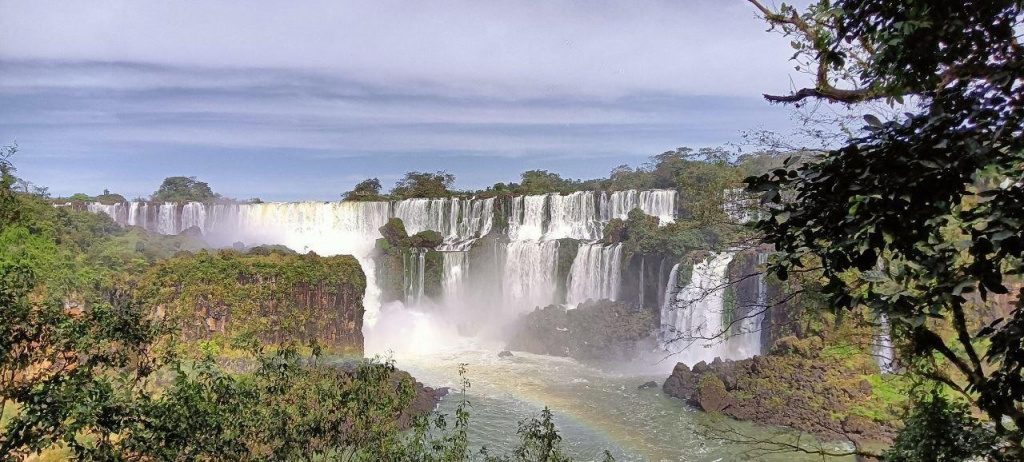 A waterfall with a rainbow in the background AI-generated content may be incorrect.